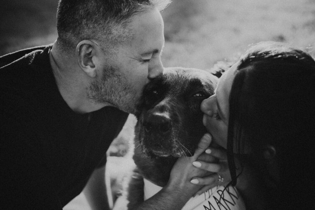 couple embracing their dog during engagement photos