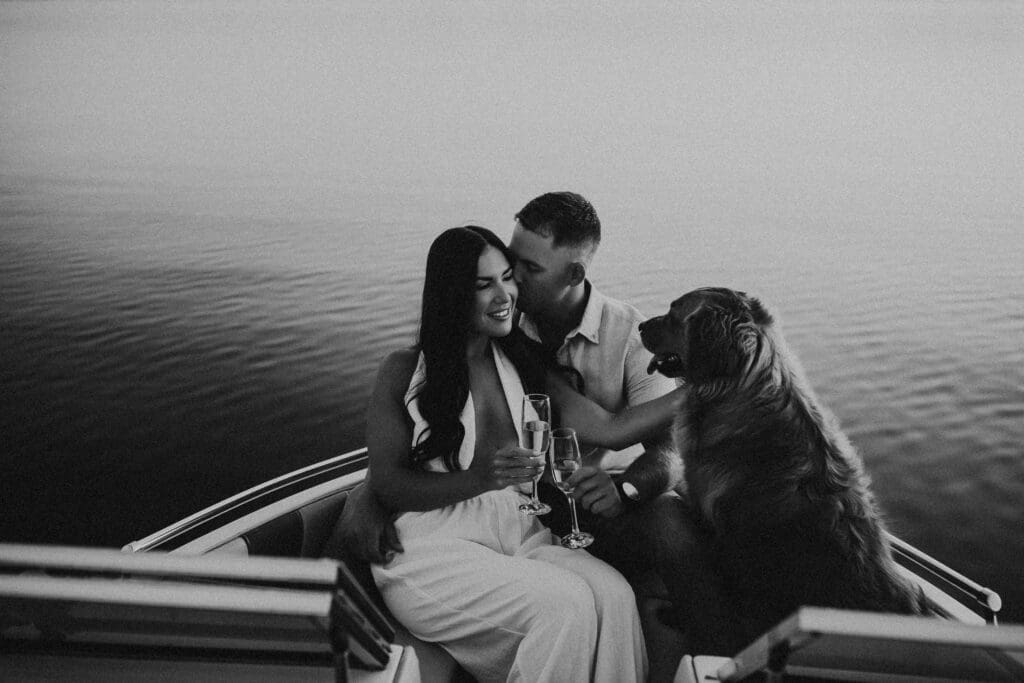 couple enjoying a champagne with their dog on a boat